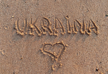 Heart-shaped sand drawing with the word written in the sandの写真素材