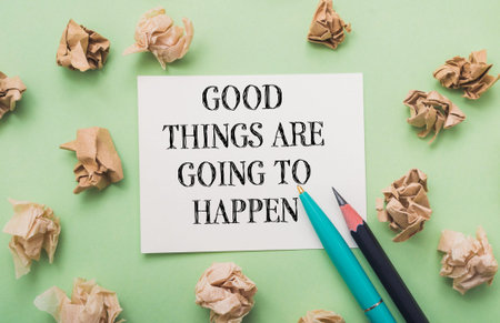 Piece of paper with the words "Good things are going to happen" written on it. There are also two pens on the paper, one of which is blueの写真素材