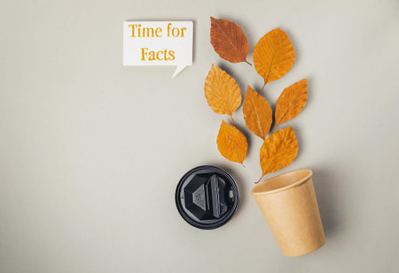 Coffee cup with a leaf on it and the words Time for Facts written above it. Concept of taking a...