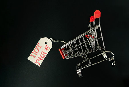 Shopping cart with a tag on it. The cart is on a black background