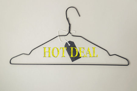 Clothes hanger with a tag that says hot deal on it. The tag is attached to the hanger with a string