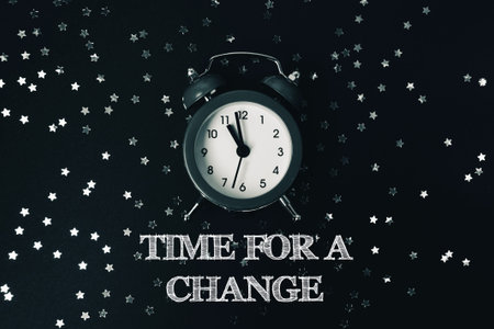 Black and white clock with the time of 10:30. The words Time for a change are written below the...