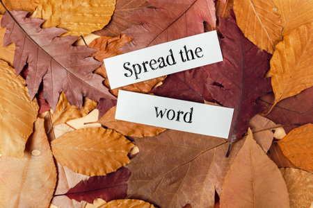 Pile of leaves with the words spread the word written on them. The leaves are brown and orange