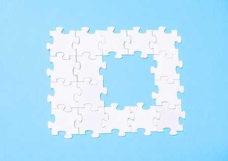 Puzzle piece is missing from a puzzle. The puzzle is white and has a blue background