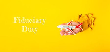 Person is holding a toy airplane. The image has a yellow background and the airplane is red and...