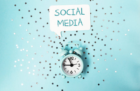 Clock with the words social media written above it. Digital marketing concept
