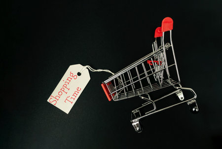 Shopping cart with a tag that says shopping time. The shopping cart is on a black background