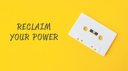 Vintage cassette tape placed on a vibrant yellow background, featuring motivational text that...
