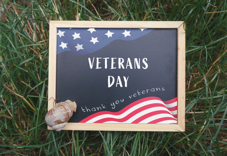 Wooden sign with a picture of an American flag and the words veterans day written on itの写真素材
