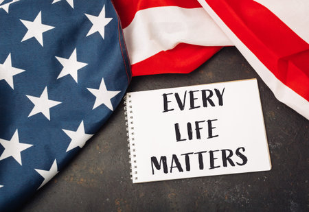 White piece of paper with the words Every Life Matters written on it. It is placed on top of a red...