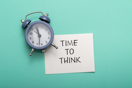 The text Time to Think on a white business card lies next to the alarm clock. business concept...
