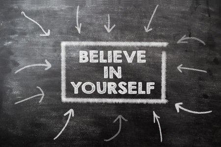 text on dark chalkboard believe in yourself. Motivational phrase do not give up in difficult times...