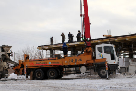 Russia, Novosibirsk 15.12.2018: The team of builders working on the construction of the building in Novosibirsk, in the winter of poured concrete using a special construction of the mixerのeditorial素材