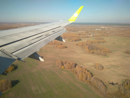 Russia, Novosibirsk, 06.10.2019: flying on the wing of an airplane landscape from above for traveling touristsのeditorial素材