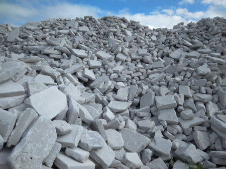 a huge pile of white broken bricks is building materials on the background of the sky stones