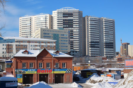 Russia, Novosibirsk, February 21, 2015: modern urban development Military street with a high business center and a car repair shopのeditorial素材