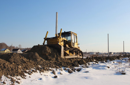 Russia, Novosibirsk 09.11.2021: a bulldozer stuck in the snow in winter, a tractor cleans the road for carsのeditorial素材