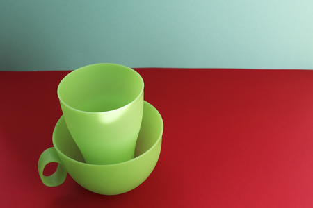 Plastic mugs are dishes for a picnic. Red background.の写真素材