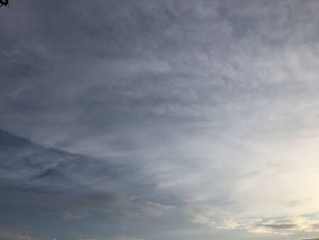 Beautiful sky painted by the sun leaving bright golden shades.Dense clouds in twilight sky in evening.Image of cloud sky on evening time.Evening sky scene with golden light from the setting sun.の写真素材