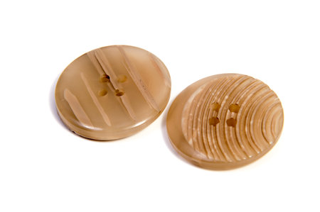 Single brown clothing button isolated over the white background