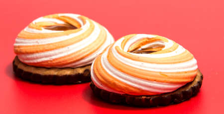 Pile of marshmallows glazed with chocolate. Many coated elegant zephyr dessert isolated on white. Sweet elegant dessert on a plateの写真素材