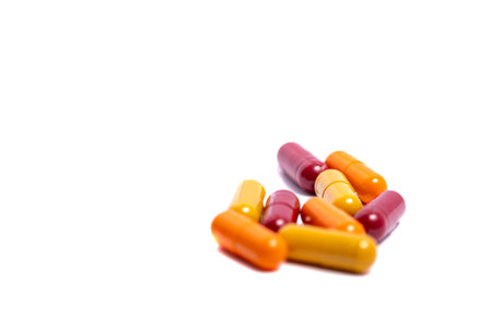 Heap of pills. Medical background. Close-up of pile of red white tablets - capsule. Pills and tablets. Blue background.の写真素材