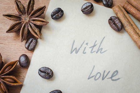 With love note and spices, sticks of cinnamon and anise star on wooden background. Coffee concept. Top view.の写真素材