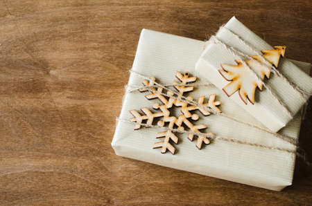Kraft Boxes with Gifts Decorated with Wooden Snowflake Christmas Tree and Jute on Wooden Background. Christmas in Rustic Style. View from above with copy space.の写真素材