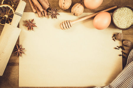 Empty paper for recipe of Christmas baking. Ingredients for Christmas baking. Spices, cutters and...