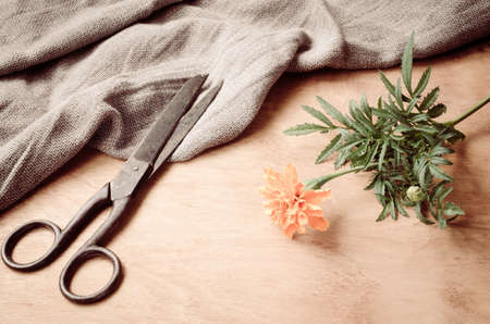 Old vintage scissors, flower and a burlap on wooden background, selective focus, rustic style.の写真素材
