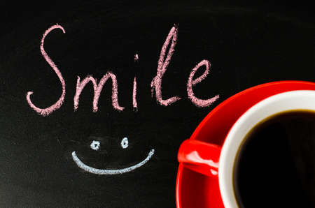 Cup of Coffee on a Dark Background. Inscription Smile. Toned Image. Selective Focus. Top View.の写真素材