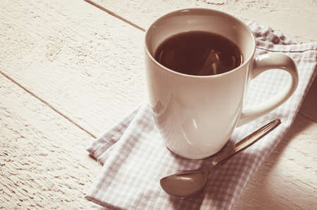 Cup of coffee on a white wooden background. Vintage tonet. Selective Focusの写真素材