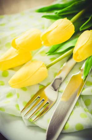 Festive Table Setting in White, Green and Yellow With Tulip. Concept Spring, Easter or Mother's Day. Selective Focus. Toned Image.の写真素材