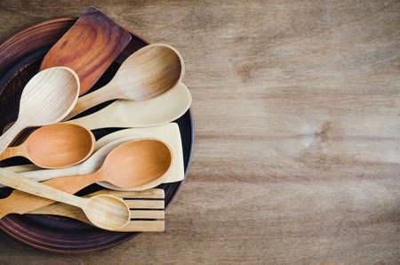 Rustic Kitchen Utensils: the Ceramic Plates and Wooden Cutlery on Wooden Background. Home Wares. Kitchen Decor in Rustic Style. View From Above With Copy Space.の写真素材