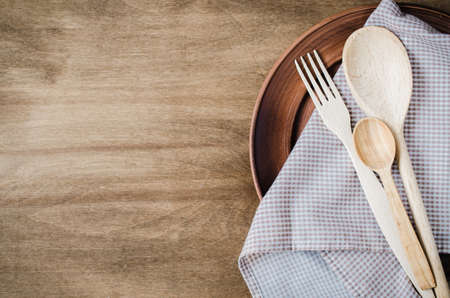 Rustic Kitchen Utensils: the Ceramic Plates and Wooden Cutlery on Wooden Background. Home Wares. Kitchen Decor in Rustic Style. View From Above With Copy Space.の写真素材
