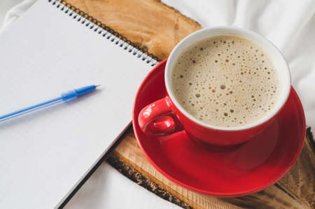 Cup of Hot Cappuccino Croissant and Chocolate in the Bed, Empty Notebook for Note. Selective Focus. Copy space.の写真素材