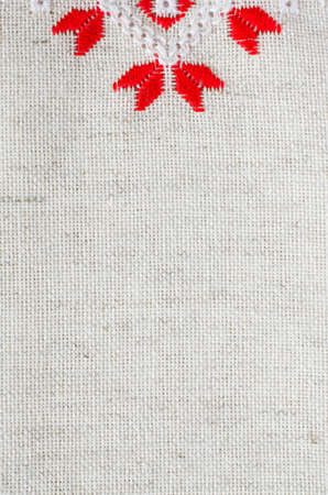 Element handmade embroidery on flax by red and white cotton threads. Design of ethnic textures. Background with embroidery. Geometric ornament.の写真素材