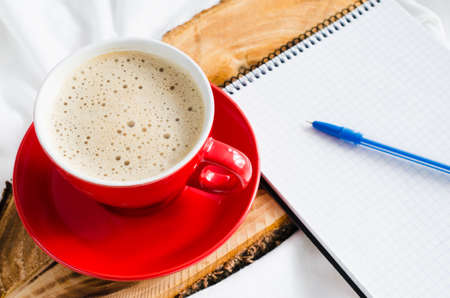 Cup of Hot Cappuccino Croissant and Chocolate in the Bed, Empty Notebook for Note. Selective Focus. Copy space.の写真素材