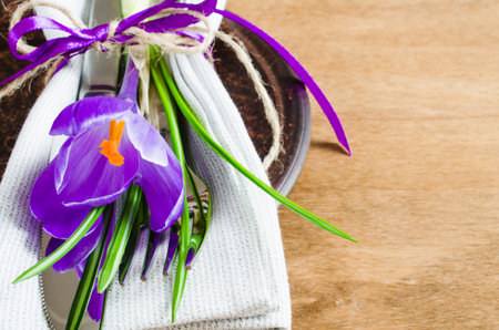 Spring Festive Table Setting With Fresh Flower. Napkin, plate and cutlery on wooden table. Holidays...