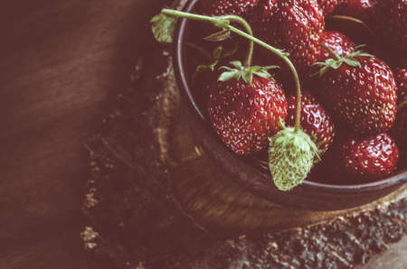 Fresh ripe organic strawberry on wooden background. Vintage rustic style and color tinting. Selective focus.の写真素材