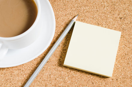 Top view image of blank notes next to cup of coffee on cork board. Ready for adding text or mockup.