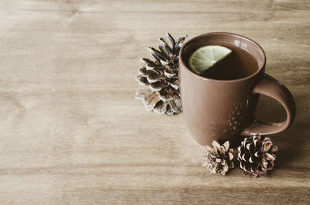 A cup of hot tea with lemon and warm plaid on a rustic table. Cozy autumnal mood, warm autumn.の写真素材