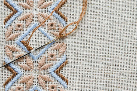 Element handmade embroidery on linen by brown and beige cotton threads. Craft embroidery. Design of ethnic pattern.の写真素材