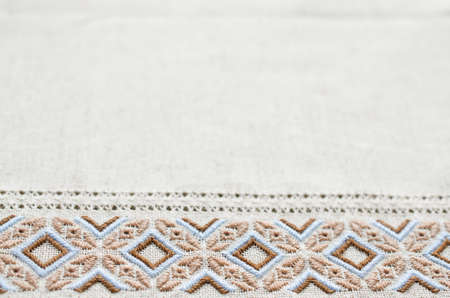 Embroidered fragment on flax by brown and beige cotton threads. Embroidery texture flat stitch. Ukrainian ethnic ornament.の写真素材