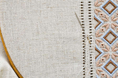 Embroidered fragment on flax by brown and beige cotton threads. Embroidery texture flat stitch. Ukrainian ethnic ornament. Hemstitch.の写真素材