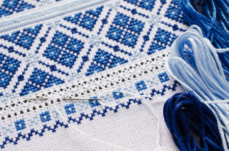 Element handmade embroidery on linen by white and blue cotton threads. Craft embroidery. Design of ethnic pattern.の写真素材