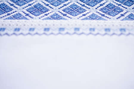 Ukrainian folk patterns embroidered with a cross on a white canvas. Slavic embroidery for background. Selective focus.の写真素材