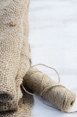 Skein jute twine and burlap on a wooden background. Rustic style. Selective focus.の写真素材