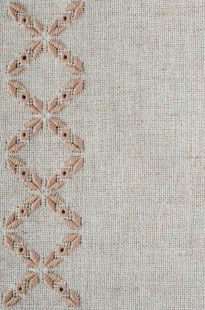 Embroidered fragment on flax by brown and beige cotton threads. Macro embroidery texture flat...