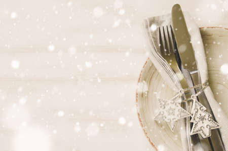 Festive table setting for Christmas holiday dinner with vintage flatware and decoration. Drawn Snow Falling Effect.の写真素材